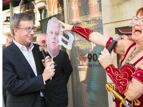 Mary Walsh, dressed as Marg Delahunty, “Princess Warrior”, “ambushes” Mayor Jim Watson, holding a cutout of Toronto Mayor Rob Ford, as a stunt to promote Cracking Up The Capital Comedy Festival that took taking place during Winterlude.