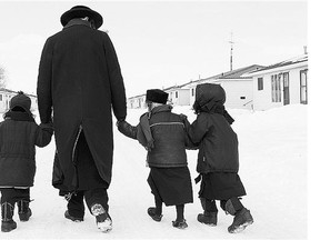 Members of the Lev Tahor sect walk down a street in Chatham, Ont., on Wednesday. Police are looking for two missing children, while 12 others have reportedly left the country.