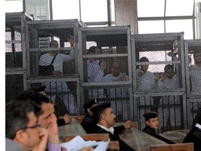 Al Jazeera English bureau chief Mohamed Fahmy, left, stands inside the defendants' cage in Cairo, at his March 5, 2014 appearance. THE CANADIAN PRESS/AP, Mohammed Abu Zaid