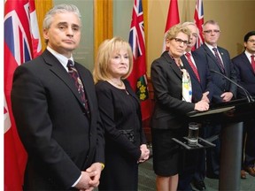 Ontario Premier Kathleen Wynne (third from left) announces a cabinet shuffle at Queen's Park in Toronto, Tuesday, March 25, 2014 as ministers (left to right) Bill Mauro (Municipal Affairs and Housing) Madeline Meilleur (Attorney General), John Gerretsen (Minister without Portfolio), Kevin Flynn (Labour) and Yasir Naqvi (Community Safety and Correctional Services) look on.