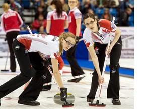 Ottawa’s Alison Kreviazuk, left, and Lisa Weagle sweep a rock during a women’s world curling championship game against Russia on March 15.