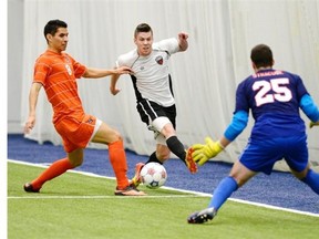 Ottawa Fury’s Carl Haworth puts pressure on Syracuse University’s Nick Perea and goaltender Alex Bono during first period action in a pre-season friendly in in Gatineau, Que. on Saturday, March 29, 2014.