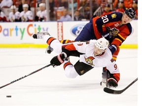 Ottawa Senators left wing Milan Michalek (9) and Florida Panthers left wing Sean Bergenheim (20) battle for the puck during the first period of an NHL hockey game, Tuesday, March 25, 2014 in Sunrise, Florida.