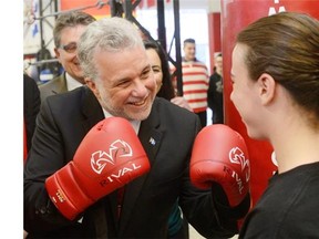 Quebec Liberal leader Philippe Couillard feigns a challenge to mixed martial arts fighter Gianni Kendall during a campaign stop for the provincial election in Montreal on Wednesday.
