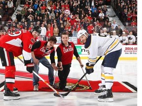 Marc Dorion, second from right, and Ben Delaney, second from left, from the Canadian Olympic sledge hockey team take part in a ceremonial faceoff with Jason Spezza No.19 of the Ottawa Senators and Steve OTT No.9 of the Buffalo Sabres  prior to an NHL game at Canadian Tire Centre on February 6, 2014 in Ottawa, Ontario, Canada.