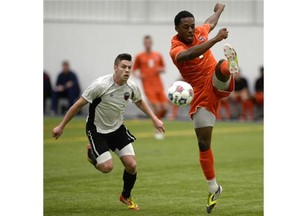 Ottawa Fury FC’s Carl Haworth looks on as Syracuse University’s Jordan Murrell kicks the ball during first-period action in a pre-season friendly in Gatineau on Saturday.