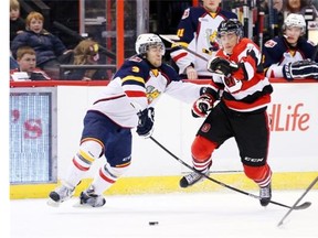 Travis Konecny #17 of the Ottawa 67’s trips over the stick of Jonathan Laser #3 of the Barrie Colts as he skates for the puck during an OHL game at Canadian Tire Centre on March 13, 2014 in Ottawa, Ontario, Canada.