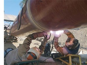 Welder join pipe during pipeline construction. TransCanada PipeLines. Handout, courtesy Canadian Energy Pipeline Association. [PNG Merlin Archive]