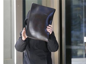 Yousef Chaouni-Benabdallah attempts to avoid photographers as he exits the Elgin Street courthouse on Friday, Chaouni, a supply teacher, was convicted by a judge sexual assault on Grade 3 students.