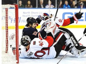 Brian Boyle #22 of the New York Rangers collides with Robin Lehner #40 and Erik Karlsson #65 of the Ottawa Senators during the second period at Madison Square Garden on April 5, 2014 in New York City.