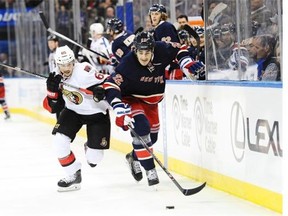 Brian Boyle #22 of the New York Rangers and Erik Karlsson #65 of the Ottawa Senators battle for the puck during the second period at Madison Square Garden on April 5, 2014 in New York City. The Senators defeat the Rangers 3-2. (Photo by Maddie Meyer/Getty Images)