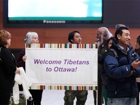 New Canadian resident Chime Palden talks with friends as he waits at the Ottawa Airport on April 5 for the welcoming of the rest of Chime’s displaced Tibetan family.