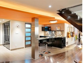 A complex lighting plan that includes recessed and accent lighting and lots of pot lights helps keep the space from feeling dark and gloomy. The round ceiling light above the bar represents the sun.
 Gordon King Photography