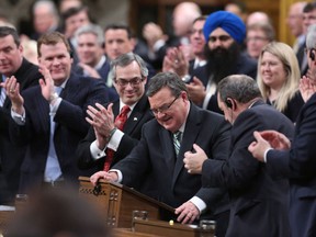 Minister of Finance Jim Flaherty is applauded by his caucus as he arrives to table the budget in the House of Commons on Parliament Hill in Ottawa on Tuesday, February 11, 2014. THE CANADIAN PRESS/Fred Chartrand