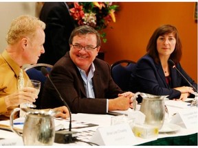 Finance Minister Jim Flaherty speaks to Brian Lee Crowley, left, Managing Director of the Macdonald-Laurier Institute, and Deputy Minister Louise Levonian, right, at his yearly policy retreat at the Wakefield Mill Inn in Wakefield, Quebec on Wednesday, August 21, 2013. THE CANADIAN PRESS/ Patrick Doyle