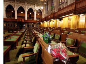 Flowers and a card of sympathy are placed in honour of former Finance Minister Jim Flaherty on a desk in the House of Commons on Parliament Hill in Ottawa on Friday, April 11, 2014.