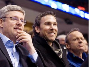 Former Vancouver Canucks captain Trevor Linden, centre, Prime Minister Stephen Harper, left, and MP Stockwell Day watch first period NHL hockey action between the Vancouver Canucks and Minnesota Wild in Vancouver on March 14, 2011. Former Vancouver Canucks captain Linden has been named the team's president of hockey operations. THE CANADIAN PRESS/Geoff Howe