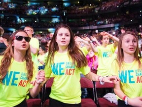 Grade 8 students Shanda Halonen, Julie Bertrim, and Sophie St. Aubin from Ecole St-Denis of Sudbury, Ont., dance along to Simple Plan at National We Day 2014 on Wednesday. Sixteen thousand students and teachers gathered at the Canadian Tire Centre in Ottawa on Wednesday.