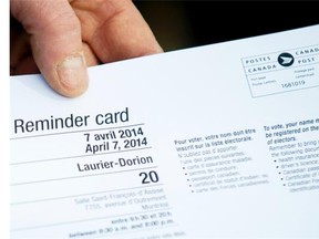 A man holds a voting card outside a polling station in Montreal Monday, April 7, 2014 prior to casting his ballot on election day in Quebec. THE CANADIAN PRESS/Graham Hughes