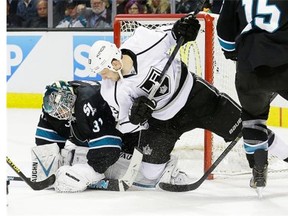 San Jose Sharks goalie Antti Niemi, from Finland, left, defends the goal next to Los Angeles Kings left wing Kyle Clifford (13) during the second period of an NHL hockey game in San Jose, Calif., Thursday, April 3, 2014. The Sharks won 2-1.