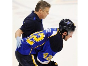 St. Louis Blues’ David Backes (42) is helped off the ice by a Blues trainer against the Chicago Blackhawks during the third period in Game 2 of a first-round NHL hockey playoff series, Saturday, April 19, 2014, in St. Louis.