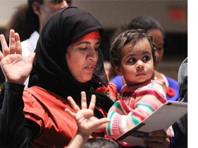 Mehreen Irum Shahid  swears allegiance to Canada holding her daughter Zohra at a citizenship ceremony in 2010. -(Bruno Schlumberger / Postmedia News)