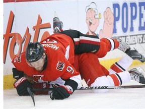 Milan Michalek of the Ottawa Senators hits John-Michael Liles of the Carolina Hurricanes during second period of NHL action at Canadian Tire Centre in Ottawa, March 31, 2014.
