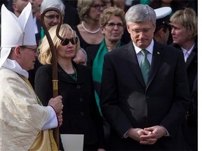 Prime Minister Stephen Harper, right, stands with his wife Laureen following Jim Flaherty's state funeral in Toronto on April 16, 2014.
