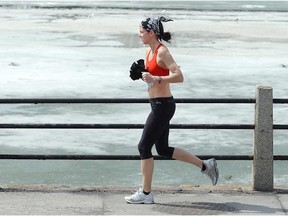 A runner makes her way along the Rideau Canal, which was still covered in ice Monday.