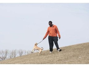 Waciira Muya, 20, plays with her puggle Chapeau on a hill in Mooney's Bay Beach on Monday, April 14, 2014. Muya came to the park to read and enjoy the warm weather.