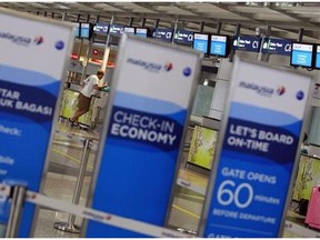 FILE - In this Tuesday, March 18, 2014 photo, a man checks in at a Malaysia Airlines counter at Kuala Lumpur International Airport in Sepang, Malaysia. (AP Photo/Lai Seng Sin, File )