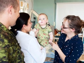 Nine-month-old Wyatt Scott, with parents Andrew Scott and Amy Miville at Children’s Hospital of Eastern Ontario on Thursday, suffers from a condition that has locked his jaw, preventing eating, drinking and speech.