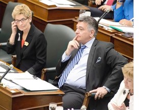 Ontario Premier Kathleen Wynne sits with Finance Minister Charles Sousa in the Ontario Legislature on Wednesday April 2, 2014.