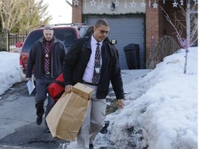 Ottawa police remove a large bag of evidence from the home of prominent realtor Chris Hoare in Orléans on Thursday. Hoare was charged with attempted murder after his wife was beaten with a baseball bat.
