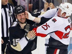 Ottawa Senators’ Chris Neil (25) lands a punch on the face of Pittsburgh Penguins’ Tanner Glass (15) during a fight in the first period of an NHL hockey game in Pittsburgh, Sunday, April 13, 2014. Both players received 5-minute penalties for fighting.