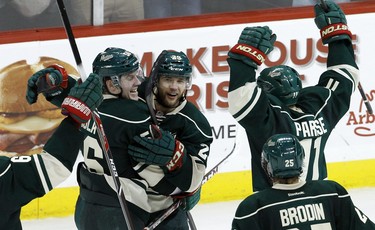 Minnesota Wild left wing Erik Haula, left, of Finland; right wing Jason Pominville, center; and left wing Zach Parise (11) celebrate Pominville's empty-net goal during the third period of Game 6 of an NHL hockey first-round playoff series against the Colorado Avalanche in St. Paul, Minn., Monday, April 28, 2014. The Wild won 5-2. (AP Photo/Ann Heisenfelt)