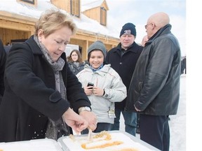 Parti Quebecois Leader Pauline Marois cuts some maple taffy as visits a sugar shack during a Quebec provincial election campaign stop in Sainte-Angele-de-Premont, Sunday, March 23, 2014. THE CANADIAN PRESS/Graham Hughes
