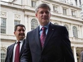 Prime Minister Stephen Harper is escorted by security and spokesman Dimitri Soudas (right) as he leaves City Hall in New York City, following a meeting with Mayor Michael Bloomberg, Tuesday, Sept.22, 2009.