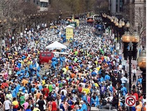 Runners mill about on Boylston Street street after completing of the 118th Boston Marathon.