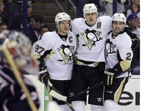 Pittsburgh Penguins' Sidney Crosby, left, Evgeni Malkin, center, of Russia, and Matt Niskanen celebrate Malkin's goal against the Columbus Blue Jackets during the first period of Game 6 of a first-round NHL playoff hockey series Monday, April 28, 2014, in Columbus, Ohio.