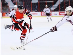 Travis Konecny (L) takes a shot with Peterborough defender Nelson Armstrong blocking in the 1st period as the Ottawa 67’s take on the Peterborough Petes in OHL action at Canadian Tire Centre.