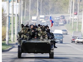Men wearing military fatigues ride on an armoured personnel carrier (APC) in the eastern Ukrainian city of Kramatorsk on April 16, 2014.  Russian leader Vladimir Putin warned that Ukraine is on the verge of civil war, the Kremlin said Wednesday, after the Kiev government sent in troops against pro-Moscow separatists in the east of the country.      AFP PHOTO / ANATOLIY STEPANOVANATOLIY STEPANOV/AFP/Getty Images