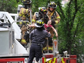 Journal photographer Shaughn Butts won a National Newspaper Award on Friday for this photo of a young victim being carried from a fire on June 16, 2013.