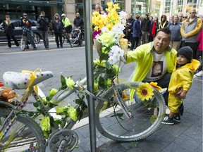 In 2012, Marc-Andre Daigle and his son Victor study the Ghost Bike In honour of the anniversary of the death of Danielle Nacu, an Ottawa cyclist.