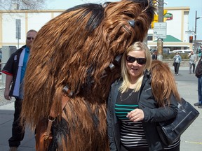 Chewbacca poses with Leslie Latham who was passing by as Ottawa Comiccon, which begins Friday at the EY Centre, held a press conference at Brother's Beer Bistro in the Byward Market. Photo taken on May 8, 2014. (Photo by Wayne Cuddington/ Ottawa Citizen)