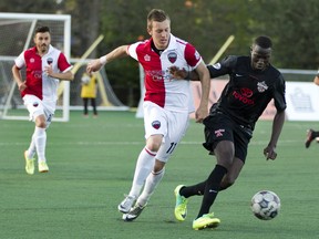 Ottawa Fury forward Oliver Minatel (left) moves in on San Antonio Scorpions forward Sainey Touray (right) during the teams NASL match-up at Keith Harris Stadium in Ottawa, May 24, 2014. (Chris Roussakis/Ottawa Citizen)