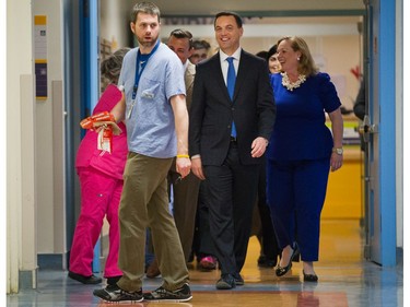 A hospital employee accidentally photo bombs a photo op with Ontario Conservative Party leader Tim Hudak as he  tours CHEO on Thursday May 22, 2014.
