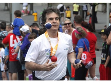 A juggler participates in the 5k run during the Ottawa Race Weekend on Saturday May 24, 2014.