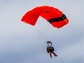A search and rescue technician (SAR tech) parachutes from a CC-130H Hercules aircraft during Tigerex 2014 at Mont Cascades Ski Resort in Cantley, Que.