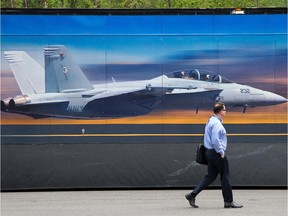 This 2014 file photo shows a visitor walking past the Super Hornet display at the CANSEC military trade show in Ottawa.
